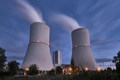 Low angle view of smoke stacks against sky