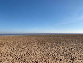 Scenic view of beach against blue sky