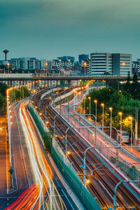High angle view of light trails on road along buildings