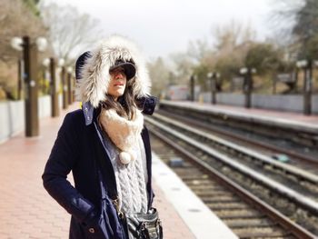 Woman standing on railroad station platform