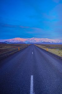 Road amidst landscape against blue sky