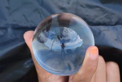 Close-up of hand holding crystal ball