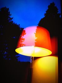 Illuminated street light against blue sky