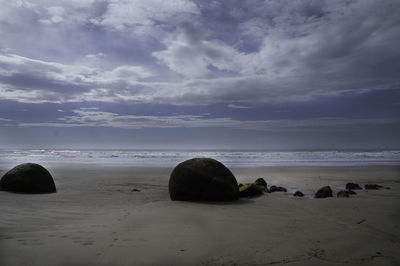 Rocks on beach against sky