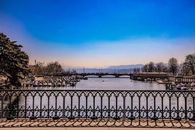 Bridge over river against sky in city