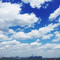 View of cityscape against cloudy sky