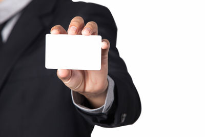 Close-up of man holding text against white background