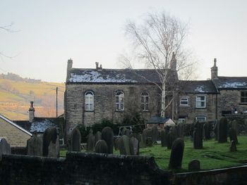 View of building and bare trees against sky