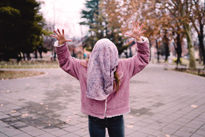 Rear view of woman standing on footpath