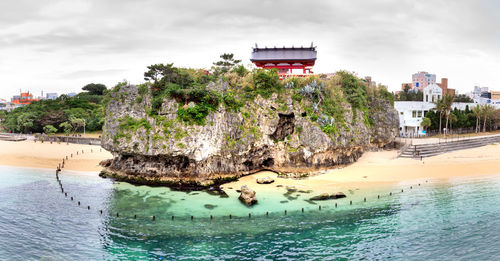 Built structure by sea against sky
