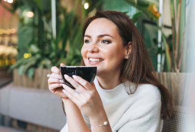 Portrait of woman holding coffee cup