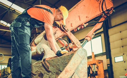 Construction worker standing on bulldozer