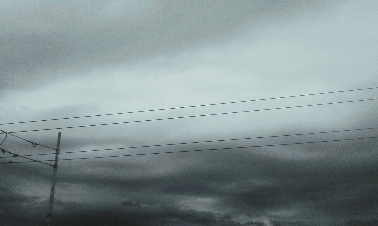 LOW ANGLE VIEW OF POWER LINES AGAINST CLOUDY SKY