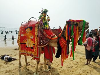 Panoramic view of people on beach against sky