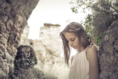 Portrait of beautiful woman standing against trees