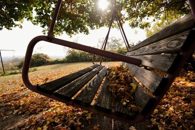 Close-up of rusty metal wheel on field against sky