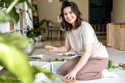 Side view of young woman sitting at home