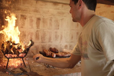 Side view of young man preparing burning