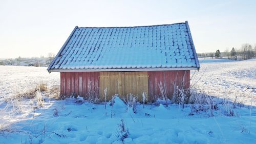 Built structure on snow covered field against sky