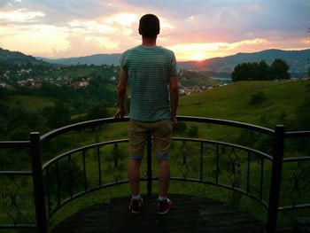 Silhouette of woman standing on landscape at sunset