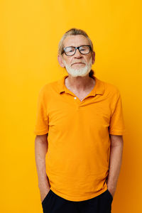 Portrait of senior man against yellow background