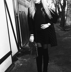 Woman with umbrella standing on sidewalk