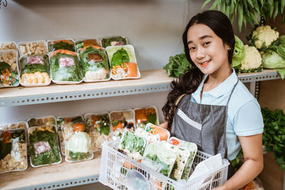 Portrait of smiling young woman standing at market