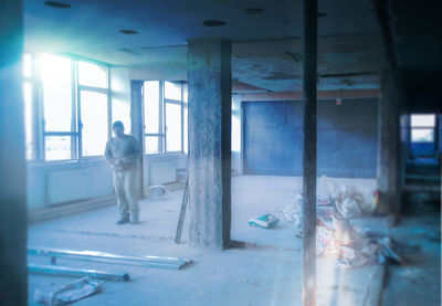 Rear view of man standing in abandoned building