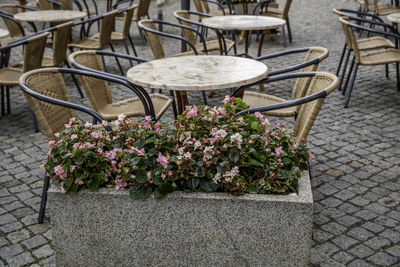 Empty chairs and tables at sidewalk cafe