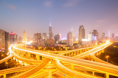 High angle view of illuminated city street and buildings at night