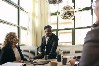 Side view of young woman using mobile phone while sitting in cafe