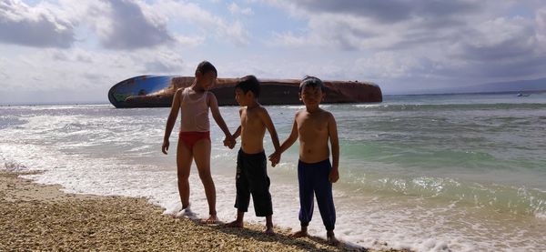 People at beach against sky