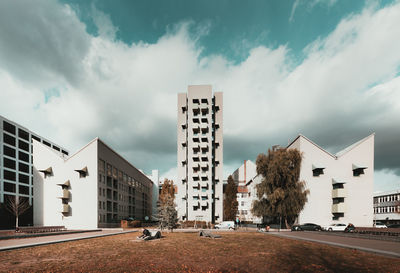 Buildings by road against sky in city