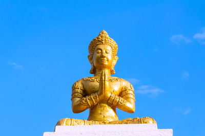 Low angle view of statue against blue sky