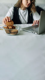 Unconscious eating. bad habits. selective focus of hand of concentrated female working on laptop at