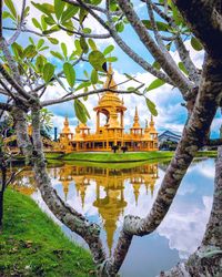 Exterior of golden temple building reflecting off lake