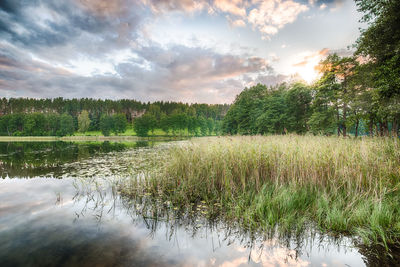 Scenic view of lake against sky at sunset