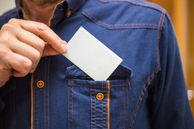 Midsection of man holding smart phone