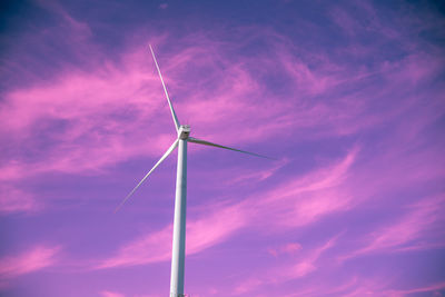 Low angle view of wind turbine against sky during sunset