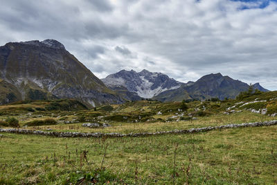 Scenic view of landscape and mountains against cloudy sky