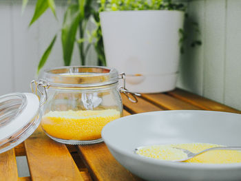 Groauts of cuscus in a glass jar and a plate on a wooden table. concept of healthy food.