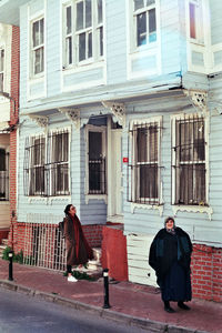 Man walking on street against building in city