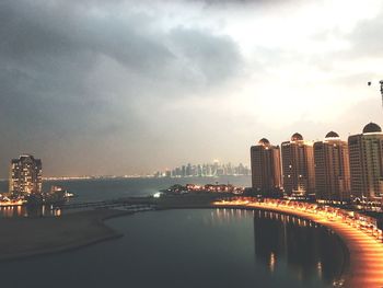 Illuminated cityscape against sky during sunset