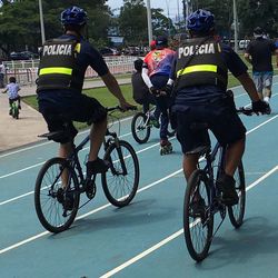 Rear view of men riding bicycle on road