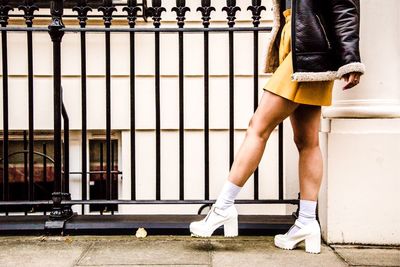 Low section of woman standing on footpath