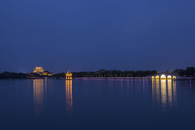 Scenic view of lake against clear blue sky at night