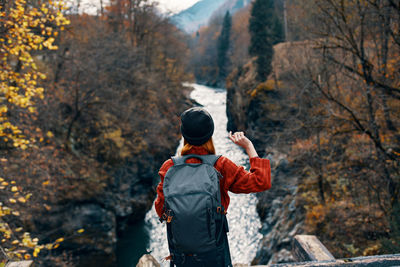 Rear view of man standing in forest during autumn