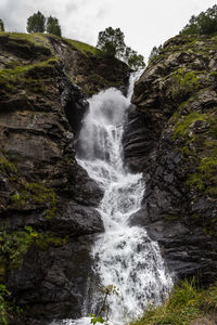 Scenic view of waterfall against sky