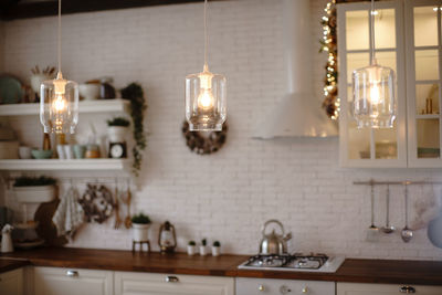 Illuminated pendant lights hanging on table at home