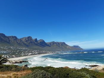 Scenic view of beach against clear blue sky